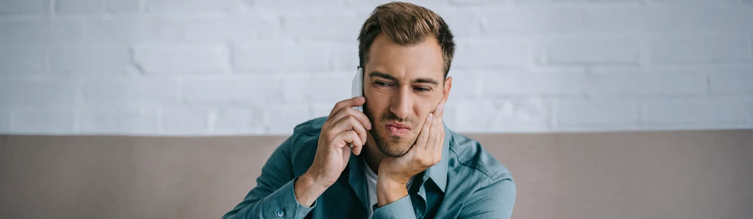 A man holding his jaw in pain.